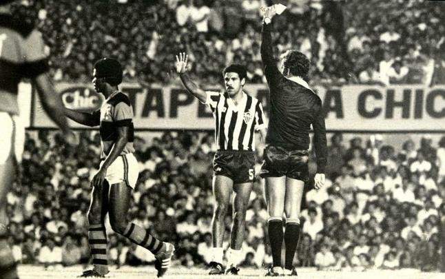 Libertadores de 1981 - Toninho Cerezo, do Atlético, recebe cartao amarelo do árbitro José Roberto Wright, em jogo realizado no Serra Dourada, em Goiás. Partida terminou em 0 a 0