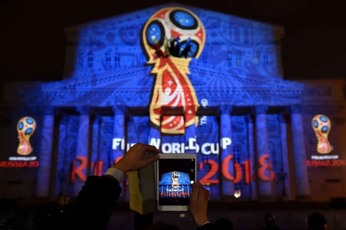 O emblema foi revelado por trs cosmonautas russos, diretamente de uma cpsula espacial, em ato que remeteu  Guerra Fria. Depois de mostrado em uma tela no estdio onde o programa foi gravado, o logo foi simultaneamente projetado em luzes na histrica sede do Teatro Bolshoi, em Moscou. Decorado em vermelho, com traos dourados e trs crculos azuis no topo, o emblema vem sendo elogiado nas redes sociais.