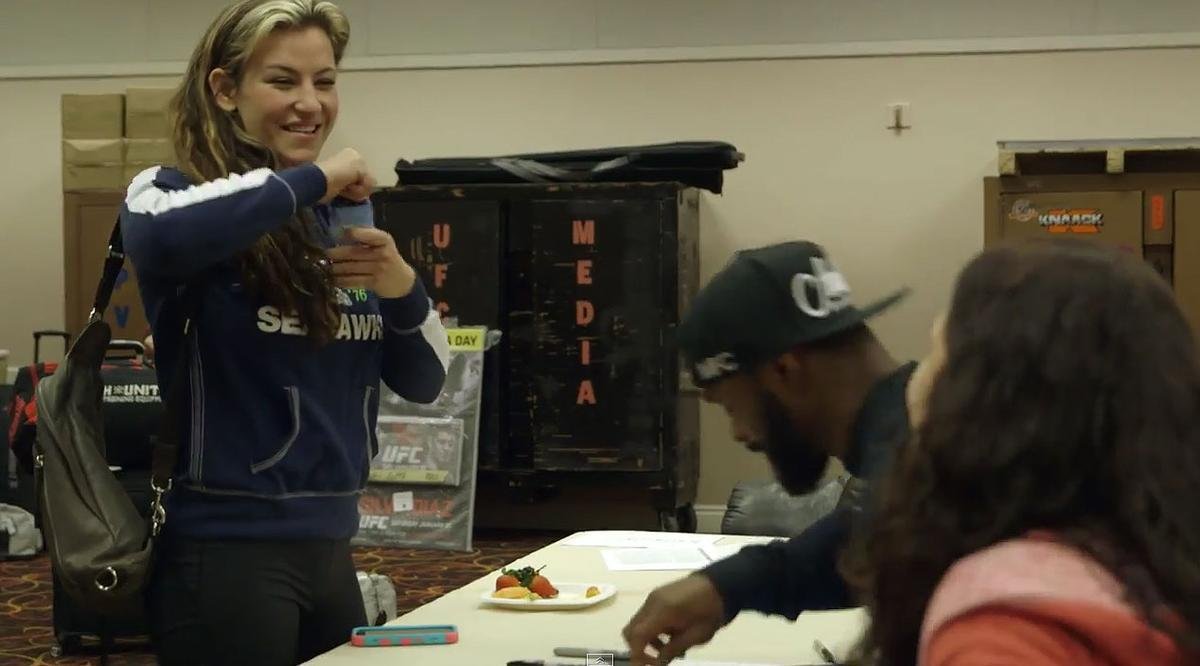 Lutadores do UFC 183 autografam cartazes do evento - Miesha Tate (e), Tyron Woodley e Sara McMann