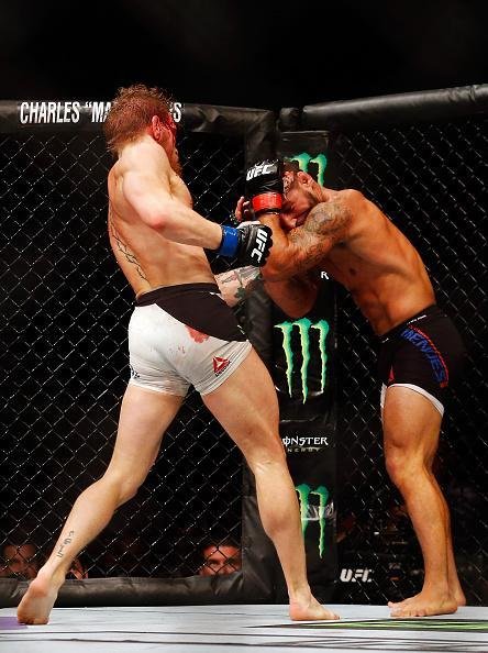 Conor McGregor (luvas azuis) venceu Chad Mendes por nocaute tcnico no segundo round e conquistou o cinturo interino dos penas