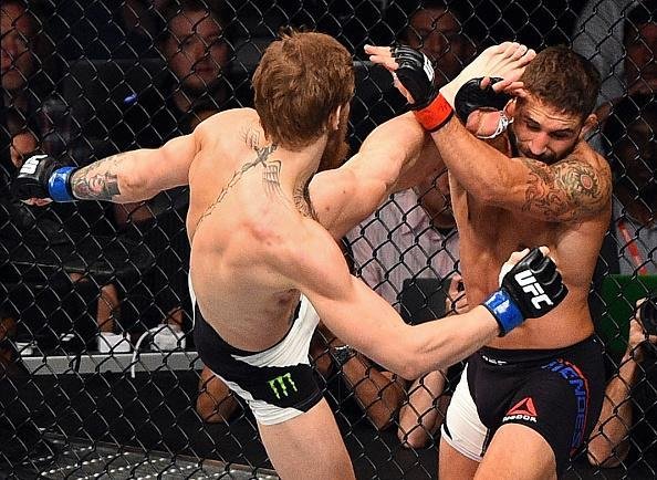 Conor McGregor (luvas azuis) venceu Chad Mendes por nocaute tcnico no segundo round e conquistou o cinturo interino dos penas