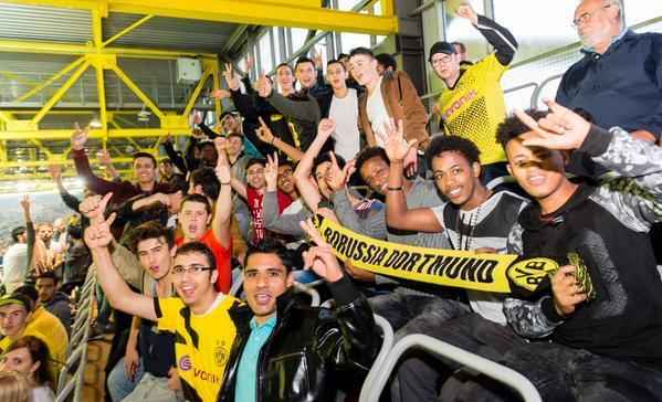 Torcedores do Borussia e refugiados assistem  partida do clube na ltima quinta-feira. 