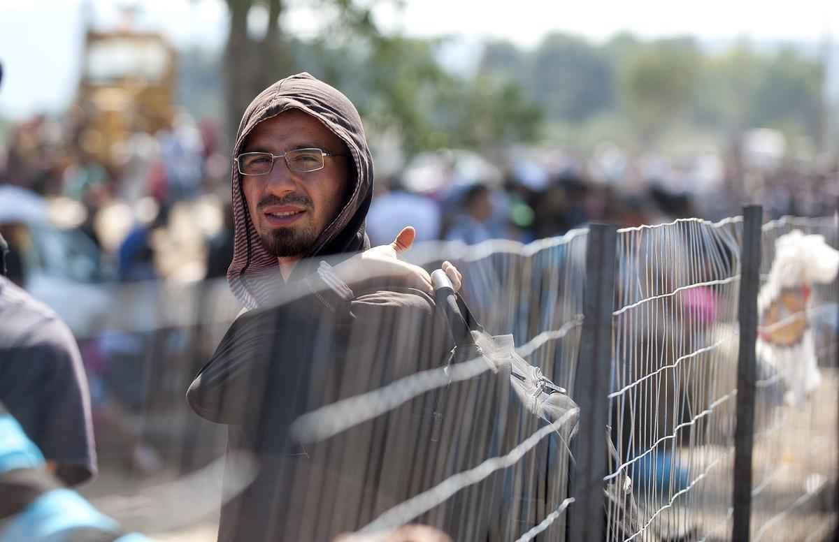 Refugiados atravessam a fronteira entre Macednia e Grcia, em busca de asilo nos pases europeus