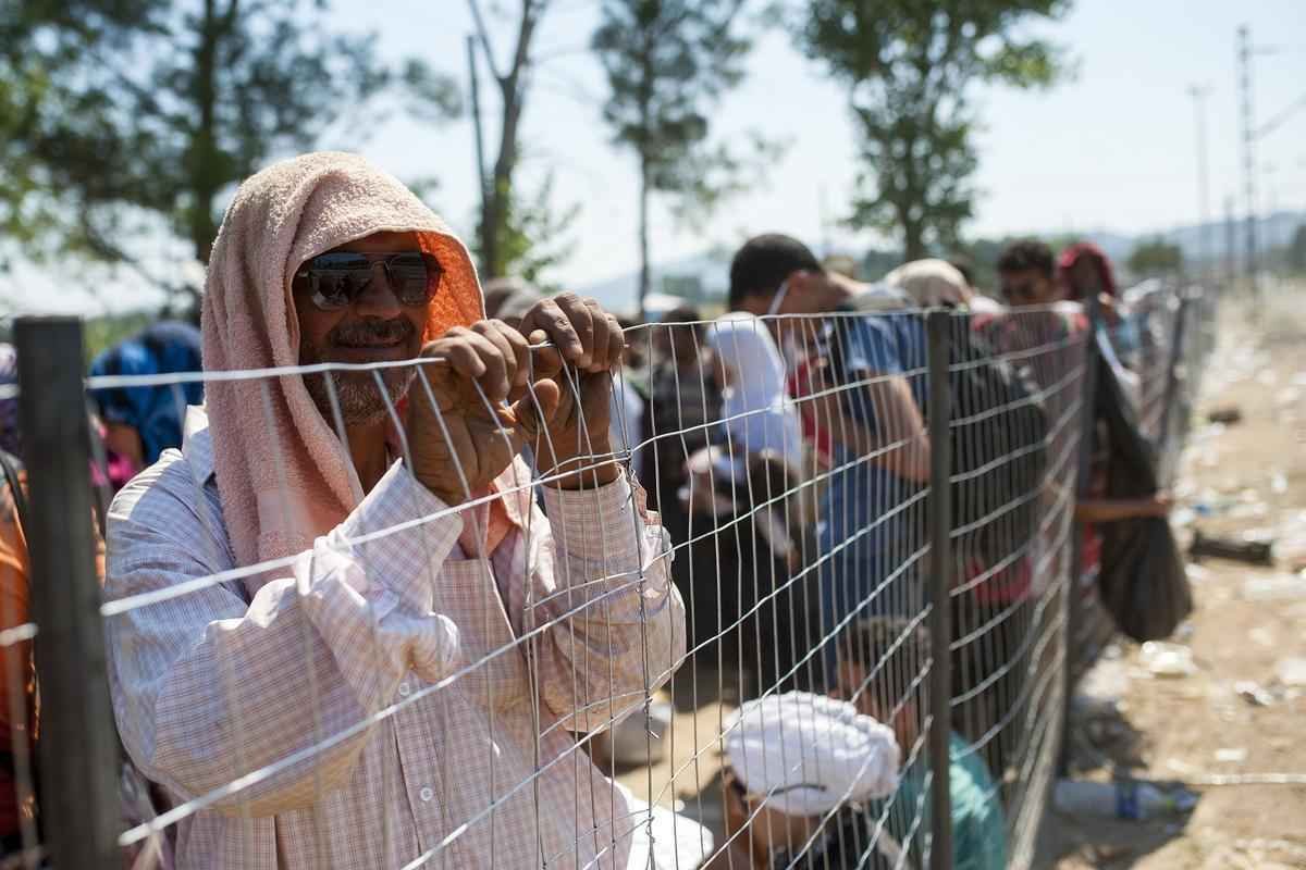 Refugiados atravessam a fronteira entre Macednia e Grcia, em busca de asilo nos pases europeus