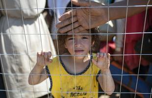 Refugiados atravessam a fronteira entre Macednia e Grcia, em busca de asilo nos pases europeus