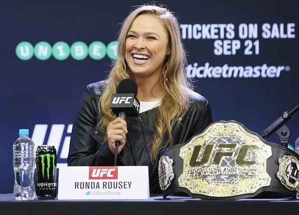 Coletiva e encaradas do UFC em Melbourne - Ronda Rousey sorri ao lado do cinturo