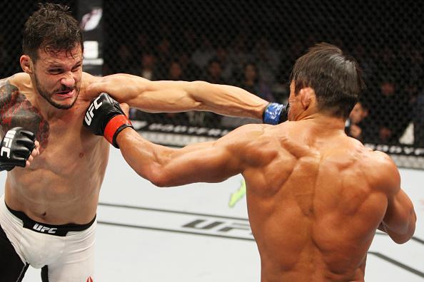 Alberto Min (luvas azuis) derrotou Yoshihiro Akiyama por deciso dividida dos jurados 