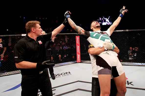 Alberto Min (luvas azuis) derrotou Yoshihiro Akiyama por deciso dividida dos jurados 