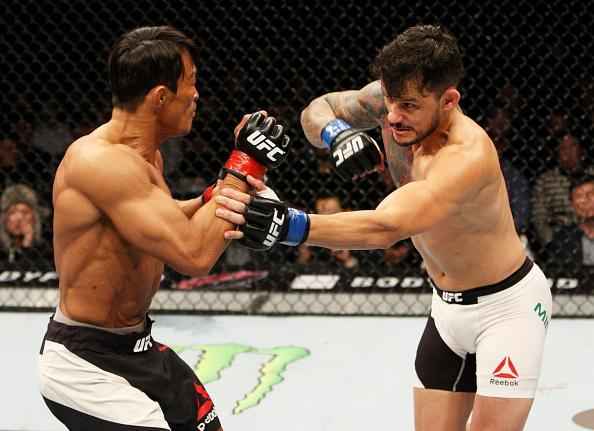 Alberto Min (luvas azuis) derrotou Yoshihiro Akiyama por deciso dividida dos jurados 