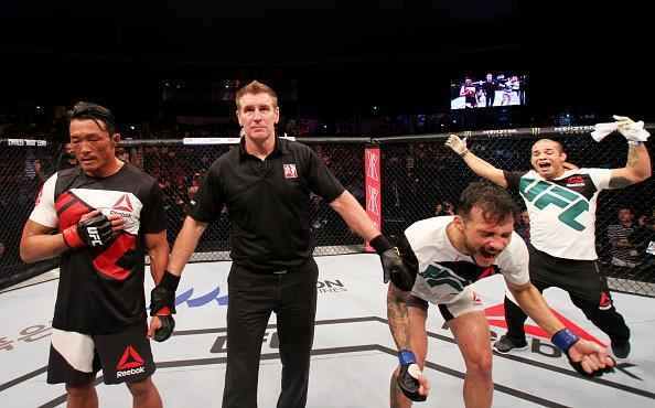 Alberto Min (luvas azuis) derrotou Yoshihiro Akiyama por deciso dividida dos jurados 