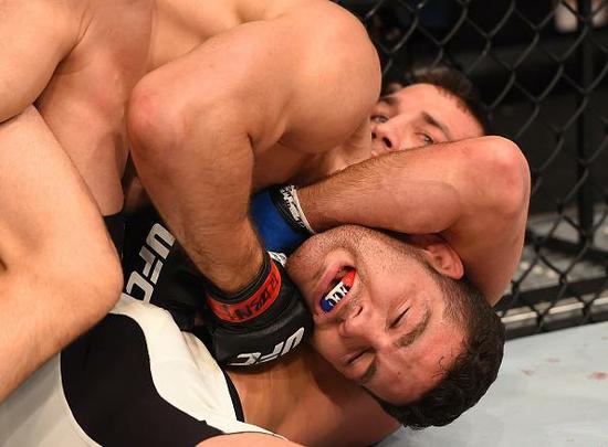 Luke Rockhold (luvas azuis) venceu Chris Weidman por nocaute técnico no quarto round e conquistou o cinturão dos médios do UFC