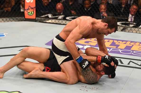 Luke Rockhold (luvas azuis) venceu Chris Weidman por nocaute técnico no quarto round e conquistou o cinturão dos médios do UFC