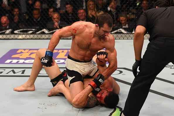 Luke Rockhold (luvas azuis) venceu Chris Weidman por nocaute técnico no quarto round e conquistou o cinturão dos médios do UFC
