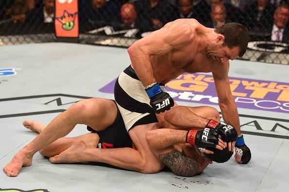 Luke Rockhold (luvas azuis) venceu Chris Weidman por nocaute técnico no quarto round e conquistou o cinturão dos médios do UFC
