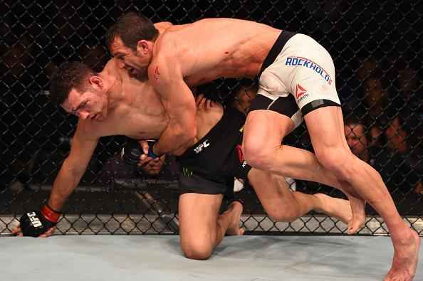 Luke Rockhold (luvas azuis) venceu Chris Weidman por nocaute técnico no quarto round e conquistou o cinturão dos médios do UFC