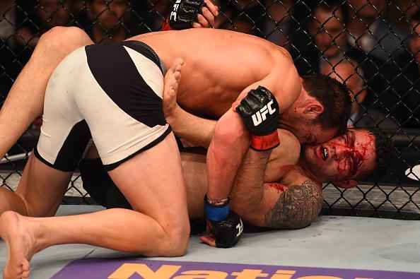 Luke Rockhold (luvas azuis) venceu Chris Weidman por nocaute técnico no quarto round e conquistou o cinturão dos médios do UFC
