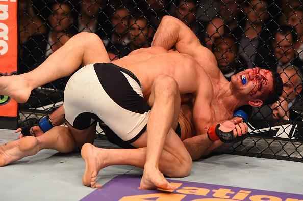 Luke Rockhold (luvas azuis) venceu Chris Weidman por nocaute técnico no quarto round e conquistou o cinturão dos médios do UFC