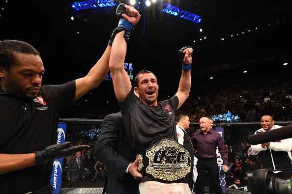 Luke Rockhold (luvas azuis) venceu Chris Weidman por nocaute técnico no quarto round e conquistou o cinturão dos médios do UFC