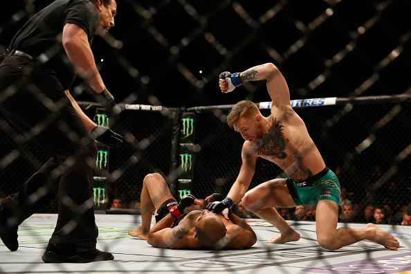 Conor McGregor (luvas azuis) venceu José Aldo por nocaute aos 13 segundos e conquistou o cinturão dos penas do UFC