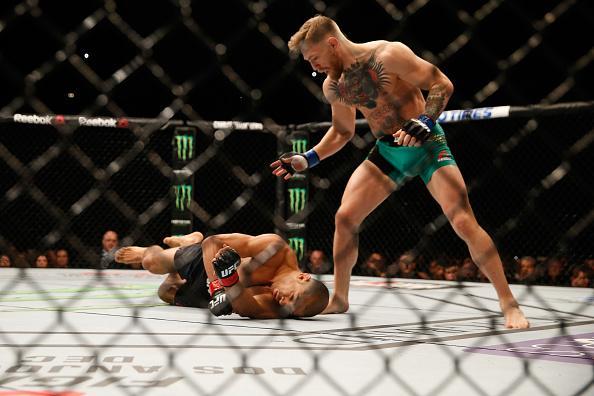 Conor McGregor (luvas azuis) venceu José Aldo por nocaute aos 13 segundos e conquistou o cinturão dos penas do UFC