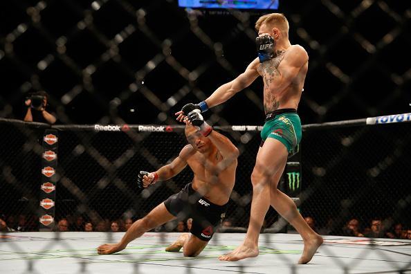 Conor McGregor (luvas azuis) venceu José Aldo por nocaute aos 13 segundos e conquistou o cinturão dos penas do UFC