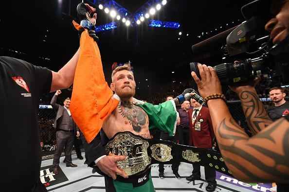 Conor McGregor (luvas azuis) venceu José Aldo por nocaute aos 13 segundos e conquistou o cinturão dos penas do UFC