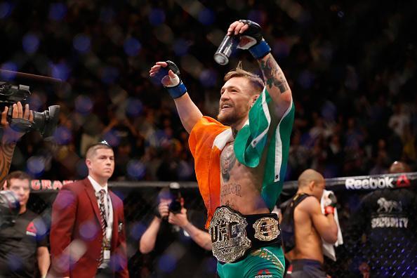 Conor McGregor (luvas azuis) venceu José Aldo por nocaute aos 13 segundos e conquistou o cinturão dos penas do UFC