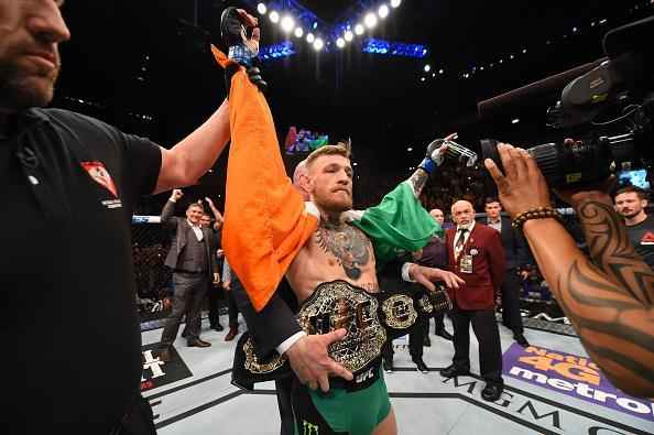 Conor McGregor (luvas azuis) venceu José Aldo por nocaute aos 13 segundos e conquistou o cinturão dos penas do UFC