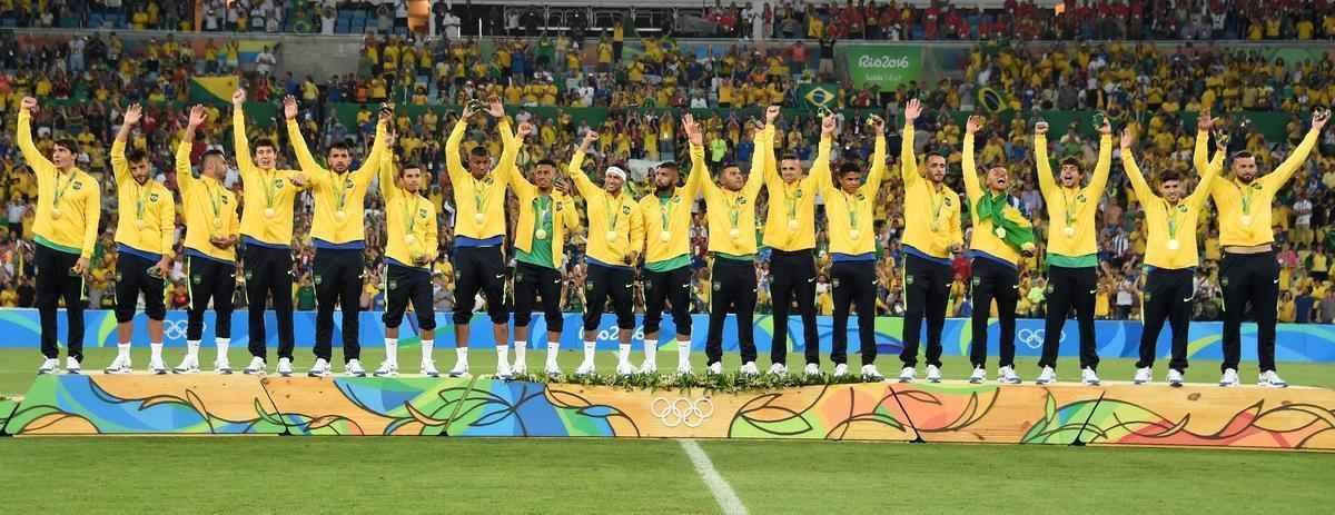 Jogadores da Seleo Brasileira sobem no pdio para receber a indita medalha de ouro no futebol. Brasil empatou por 1 a 1 com a Alemanha na deciso, e deciso foi para os pnaltis aps a prorrogao. Nas batidas, a Seleo fez 5 a 4.