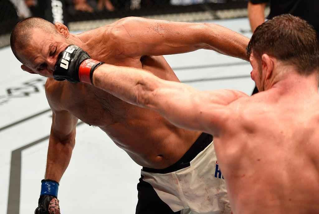 Michael Bisping (luvas vermelhas) venceu Dan Henderson por deciso unnime e manteve o cinturo dos mdios