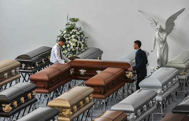 Funcionários da funerária preparam os caixões dos jogadores e comissão técnica da Chapecoense