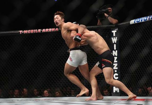 Dong Hyun Kim (luvas vermelhas) venceu Tarec Saffiedine por decisão dividida (30-27, 28-29, 29-28)