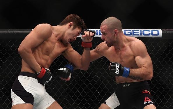 Dong Hyun Kim (luvas vermelhas) venceu Tarec Saffiedine por deciso dividida (30-27, 28-29, 29-28)