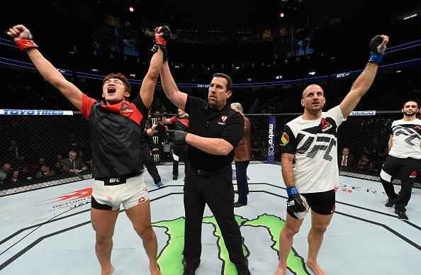 Dong Hyun Kim (luvas vermelhas) venceu Tarec Saffiedine por decisão dividida (30-27, 28-29, 29-28)