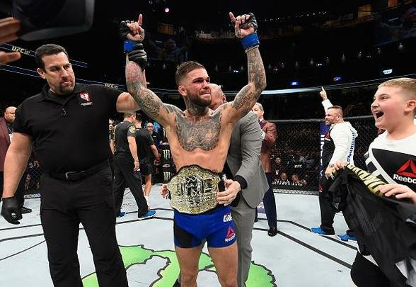 Cody Garbrandt (luvas azuis) venceu Dominick Cruz por decisão unânime e conquistou o cinturão dos galos