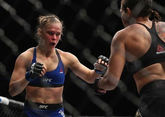Amanda Nunes (luvas vermelhas) venceu Ronda Rousey por nocaute técnico em 48 segundos e manteve o cinturão dos galos