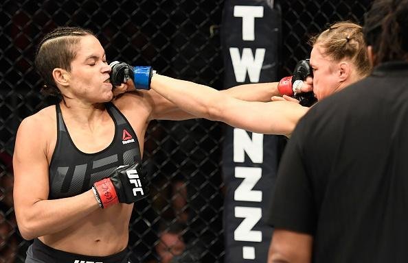 Amanda Nunes (luvas vermelhas) venceu Ronda Rousey por nocaute técnico em 48 segundos e manteve o cinturão dos galos