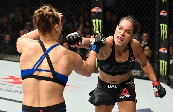Amanda Nunes (luvas vermelhas) venceu Ronda Rousey por nocaute tcnico em 48 segundos e manteve o cinturo dos galos