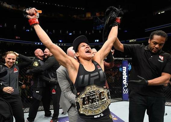 Amanda Nunes (luvas vermelhas) venceu Ronda Rousey por nocaute técnico em 48 segundos e manteve o cinturão dos galos