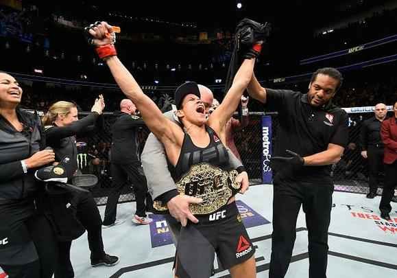 Amanda Nunes (luvas vermelhas) venceu Ronda Rousey por nocaute técnico em 48 segundos e manteve o cinturão dos galos