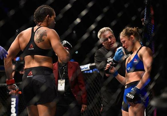Amanda Nunes (luvas vermelhas) venceu Ronda Rousey por nocaute técnico em 48 segundos e manteve o cinturão dos galos