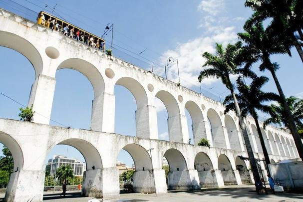 Arco da Lapa - O Aqueducto da Carioca, popularmente conhecido como os Arcos da Lapa,  um dos principais cartes postais da cidade e uma memria viva e bem conservada do Rio Antigo.  considerada a obra arquitetnica de maior porte do o perodo colonial. A imponente construo em estilo romano tem 17,6 metros de altura, 270 metros de extenso e 42 arcos em estilo romano , que ligam o bairro de Santa Teresa ao Morro de Santo Antnio. 