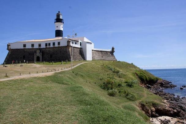 Farol da Barra - Um dos mais conhecidos postais da Bahia. O farol original foi instalado no forte no ano de 1698, sendo o primeiro de toda a Amrica. O leo de baleia alimentava lampies protegidos por vidros que sinalizavam para os navegantes a entrada da baa. Sucessivas reformas transformaram o farol original em 1839, 1890 e 1937, quando ele foi finalmente eletrificado. Nele est o Museu Nutico da Bahia.