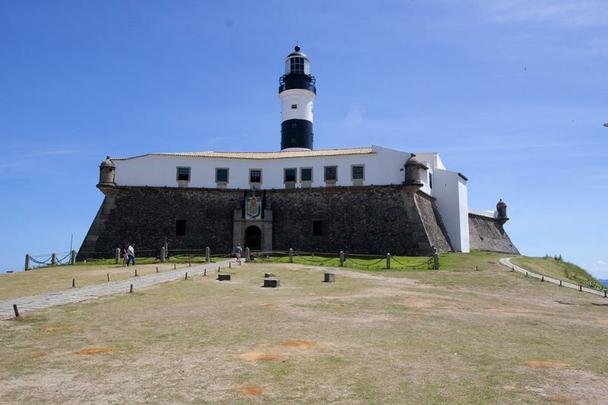Farol da Barra - Um dos mais conhecidos postais da Bahia. O farol original foi instalado no forte no ano de 1698, sendo o primeiro de toda a Amrica. O leo de baleia alimentava lampies protegidos por vidros que sinalizavam para os navegantes a entrada da baa. Sucessivas reformas transformaram o farol original em 1839, 1890 e 1937, quando ele foi finalmente eletrificado. Nele est o Museu Nutico da Bahia.