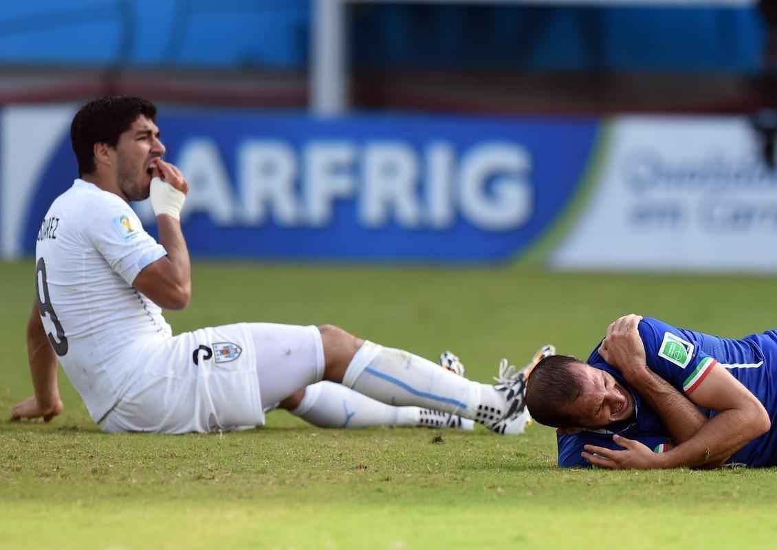 Atacante Luis Surez de uma mordida no zagueiro italiano Chiellini no segundo tempo do duelo entre as selees na Arena das Dunas, em Natal; cmeras de longo alcance flagraram marcas no ombro da 'vtima'