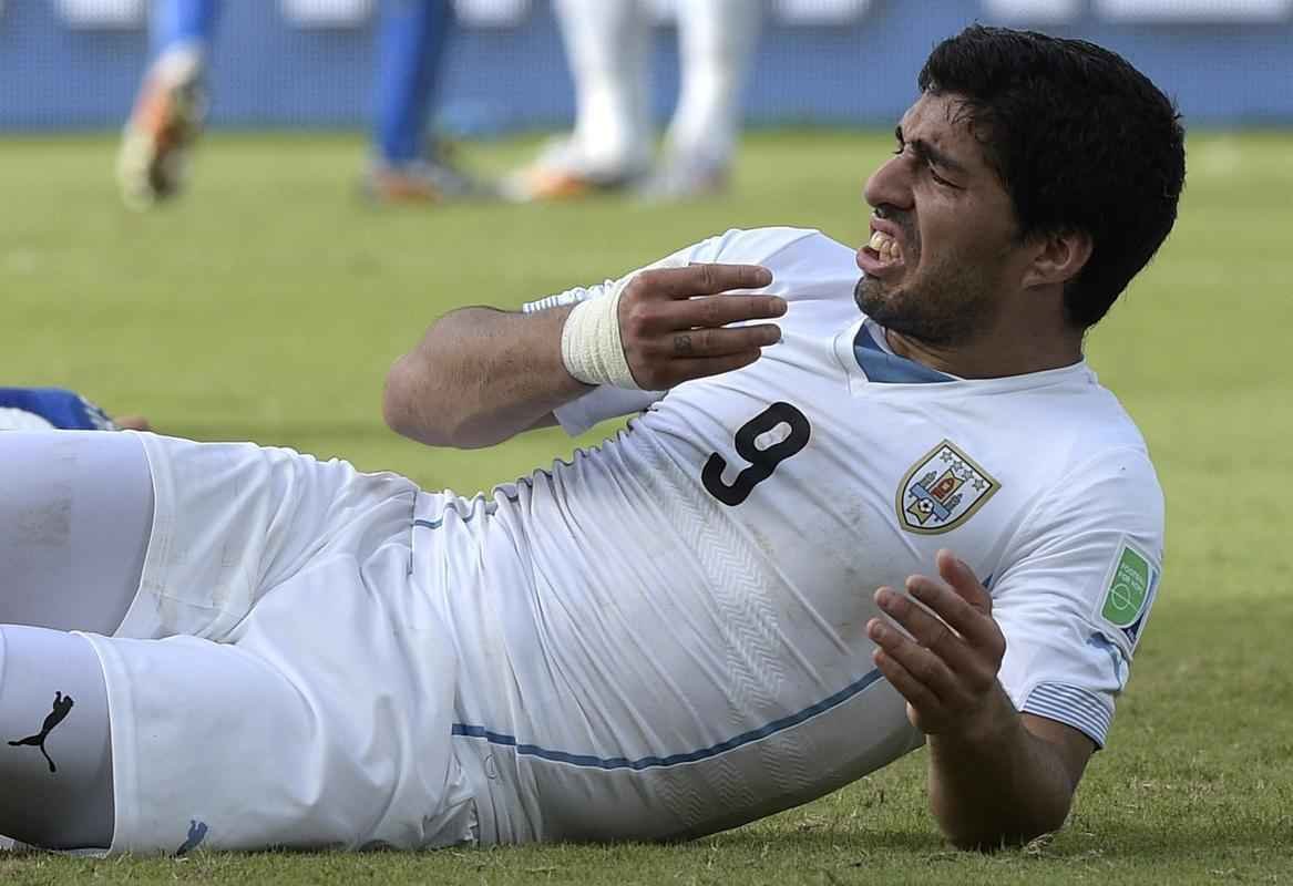 Atacante Luis Surez de uma mordida no zagueiro italiano Chiellini no segundo tempo do duelo entre as selees na Arena das Dunas, em Natal; cmeras de longo alcance flagraram marcas no ombro da 'vtima'