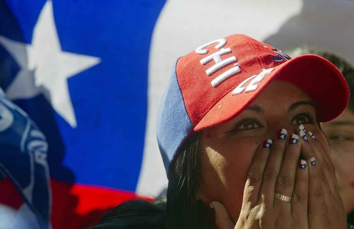 Nas ruas de Santiago, capital do Chile, torcedores da 'Roja' assistem  eliminao diante do Brasil na Copa do Mundo