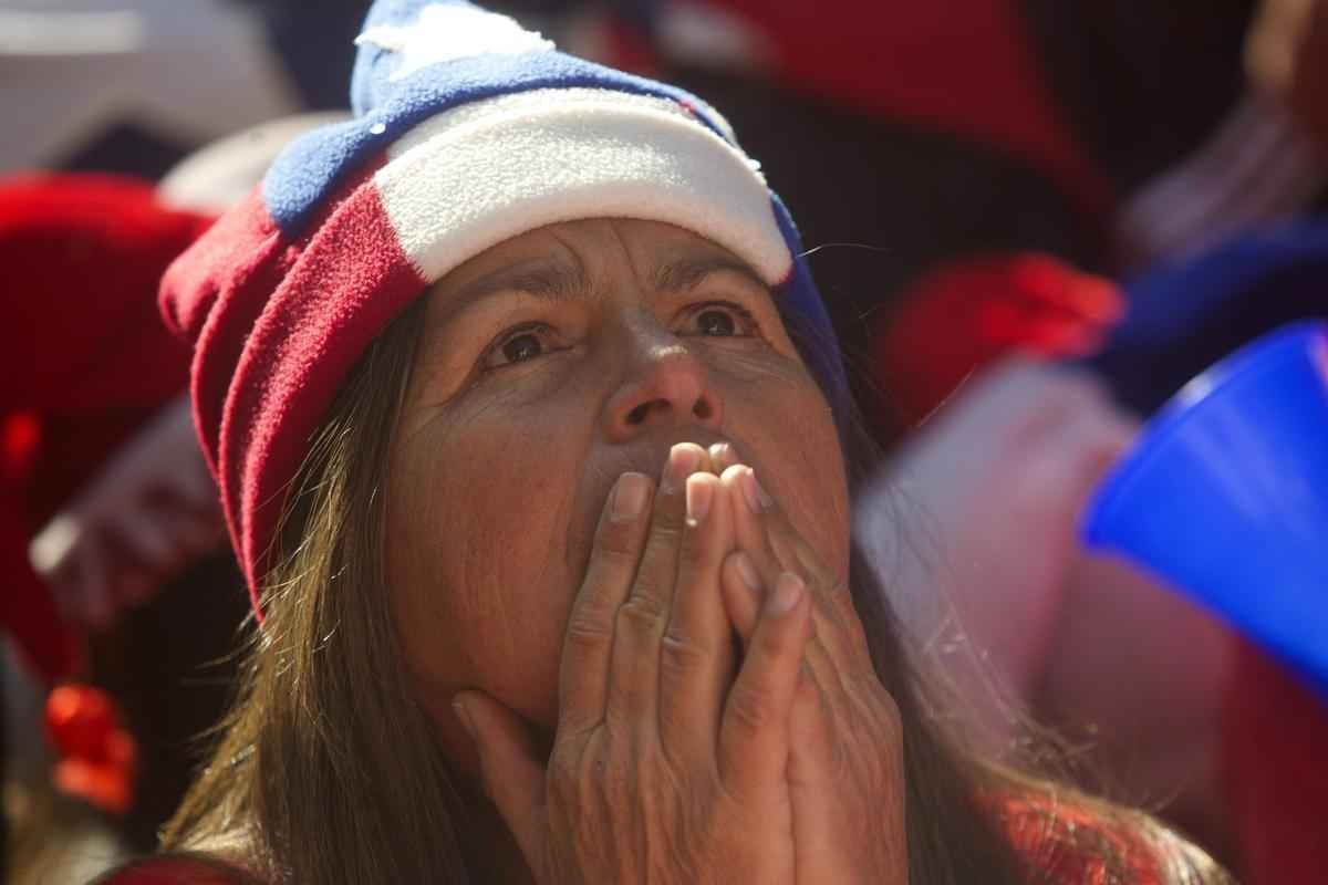 Nas ruas de Santiago, capital do Chile, torcedores da 'Roja' assistem  eliminao diante do Brasil na Copa do Mundo