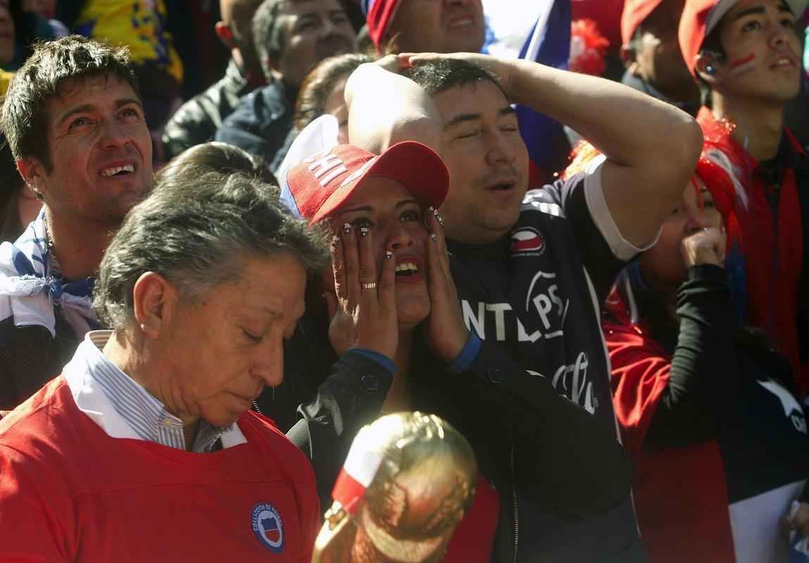 Nas ruas de Santiago, capital do Chile, torcedores da 'Roja' assistem  eliminao diante do Brasil na Copa do Mundo