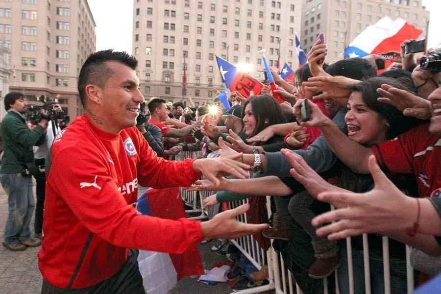 Multido e presidente receberam Seleo Chilena no Palcio de La Moneda, em Santiago. Populao reconheceu a boa campanha da equipe na Copa do Mundo, da qual foi eliminada pelo Brasil, nos pnaltis, por 3 a 2 (empate em 1 a 1 no tempo normal).